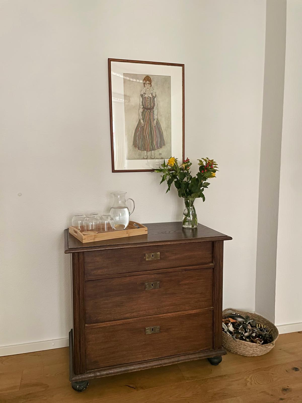 Ruhige Ecke in der Praxis mit antiker Kommode, Blumen und gerahmtem Portrait